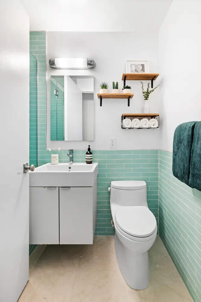 a bathroom with a toilet sink and mirror