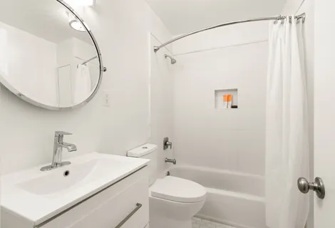 a bathroom with a sink a toilet and a mirror