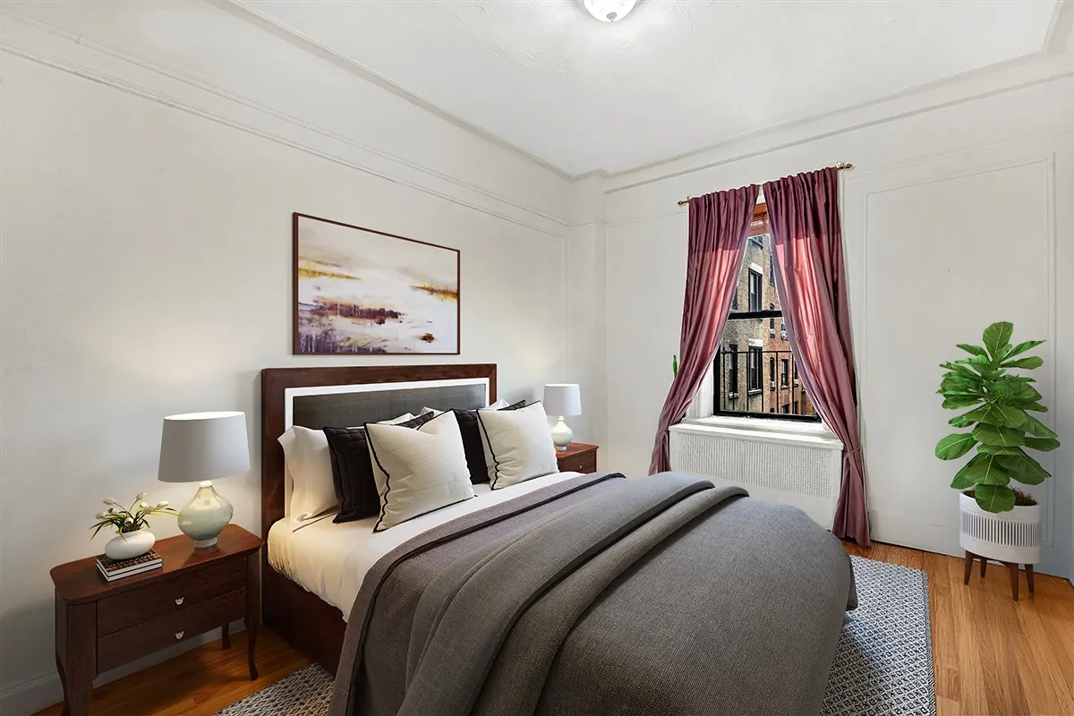 a bedroom with a bed and a potted plant