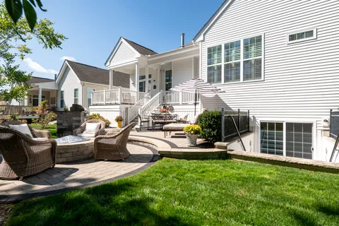 a view of a house with backyard and sitting area