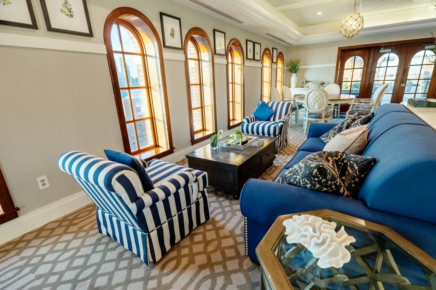 a living room with furniture and three windows