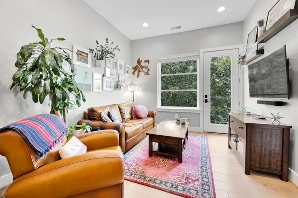 a living room with furniture a flat screen tv and a fireplace