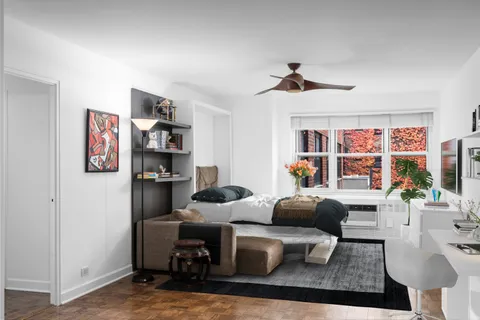 a living room with furniture a chandelier and a window