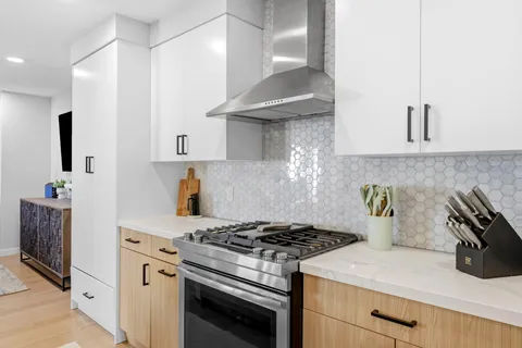 a white stove top oven sitting inside of a kitchen
