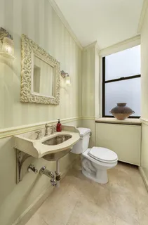 a bathroom with a sink mirror toilet and window