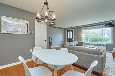 a dining room with furniture a chandelier and window