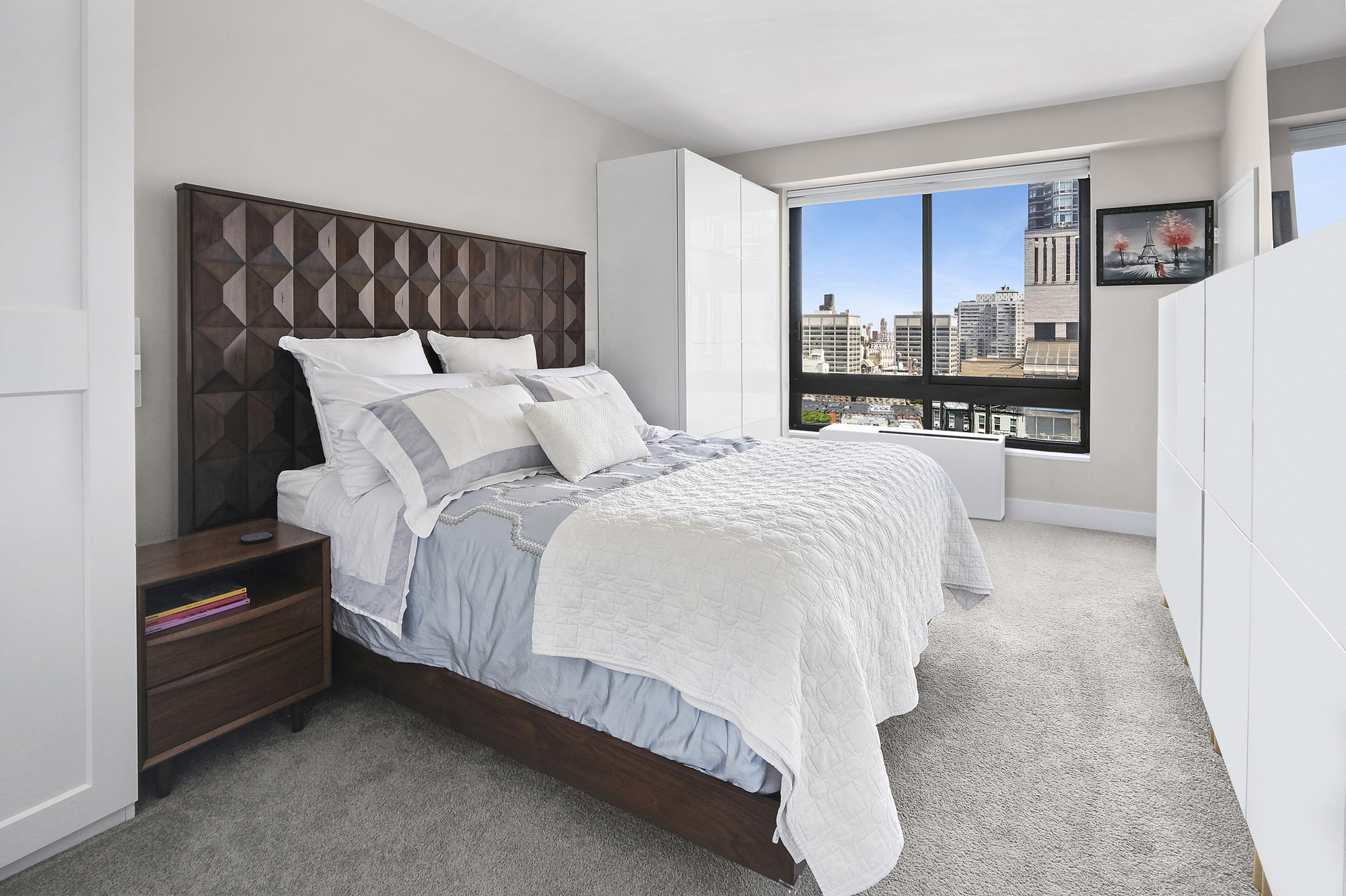 167 East 61st Street, Unit 23D Manhattan, NY 10065 - Photo 3 of 13 a bed sitting in a bedroom and view of kitchen