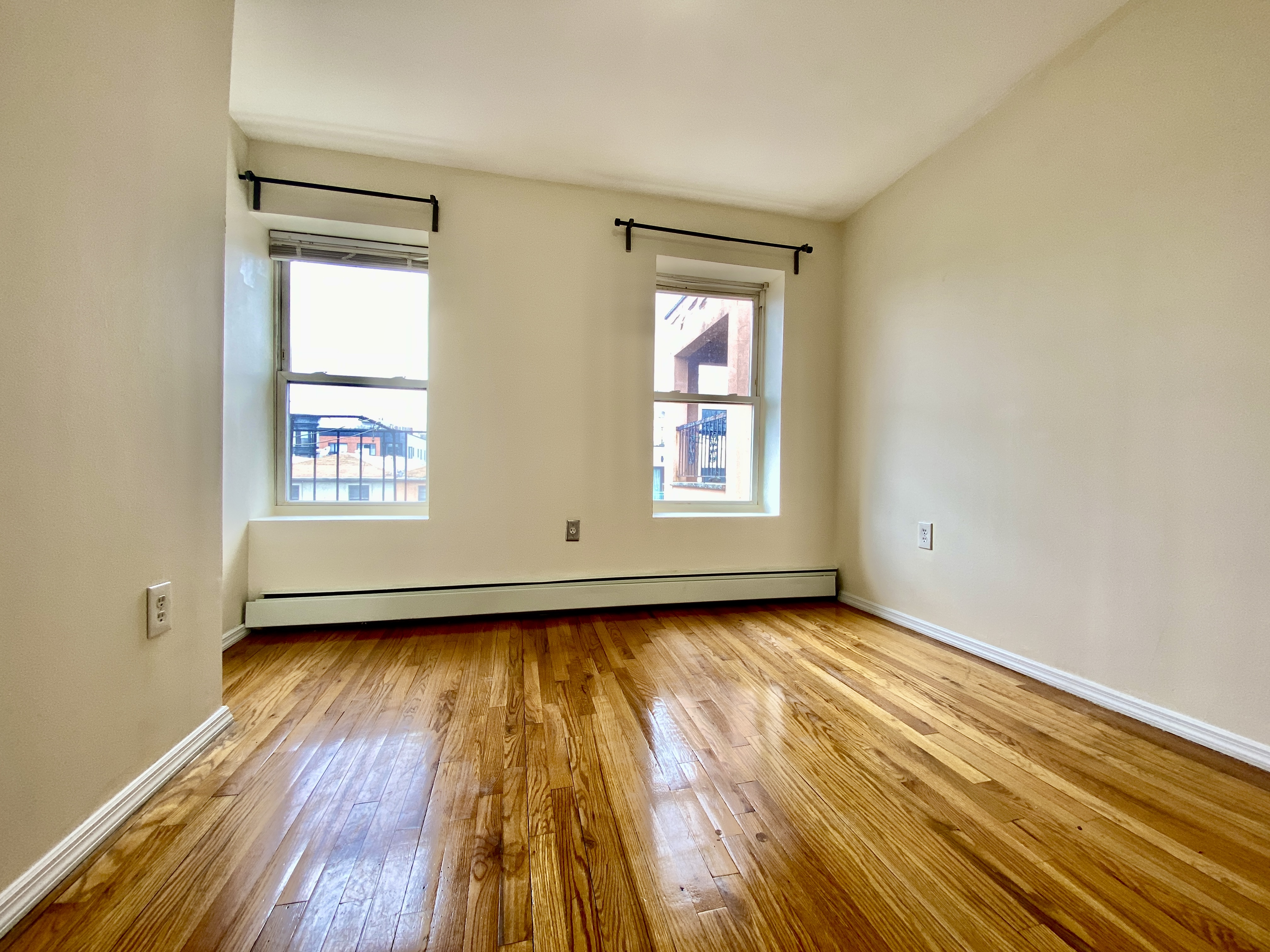 373 Gates Avenue, Unit 4 Brooklyn, NY 11216 - Photo 7 of 10 an empty room with wooden floor and windows