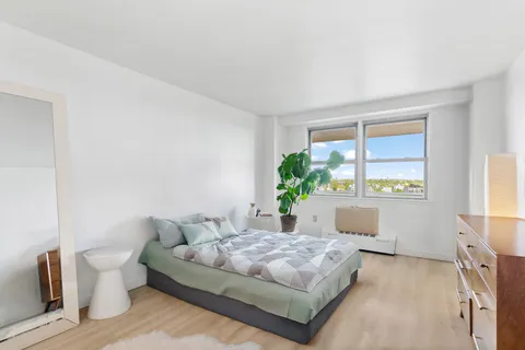 a spacious bedroom with a bed and a window