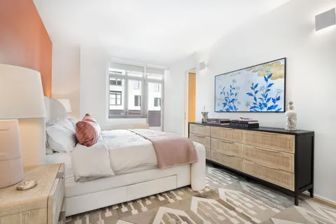 a bedroom with a bed and a painting on the wall