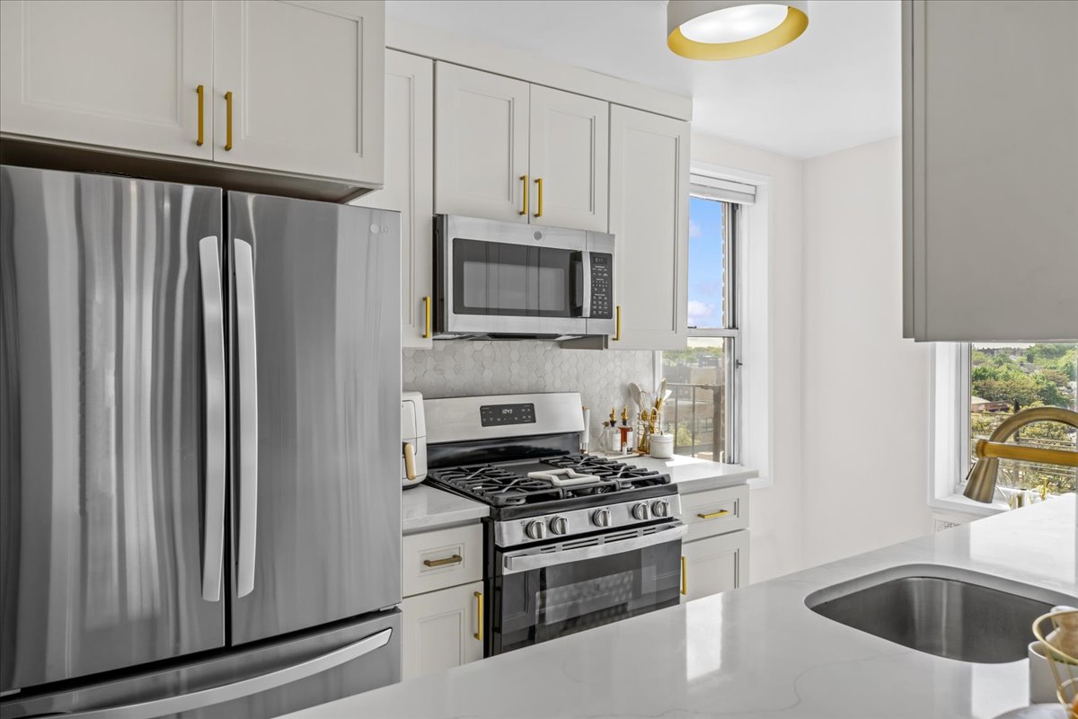 759 East 10th Street, Unit 7H Brooklyn, NY 11230 - Photo 6 of 15 a kitchen with stainless steel appliances a stove a microwave and a sink
