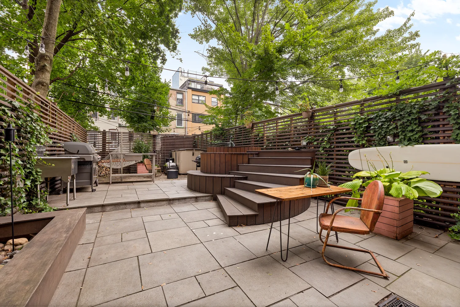 a backyard of a house with barbeque oven table and chairs