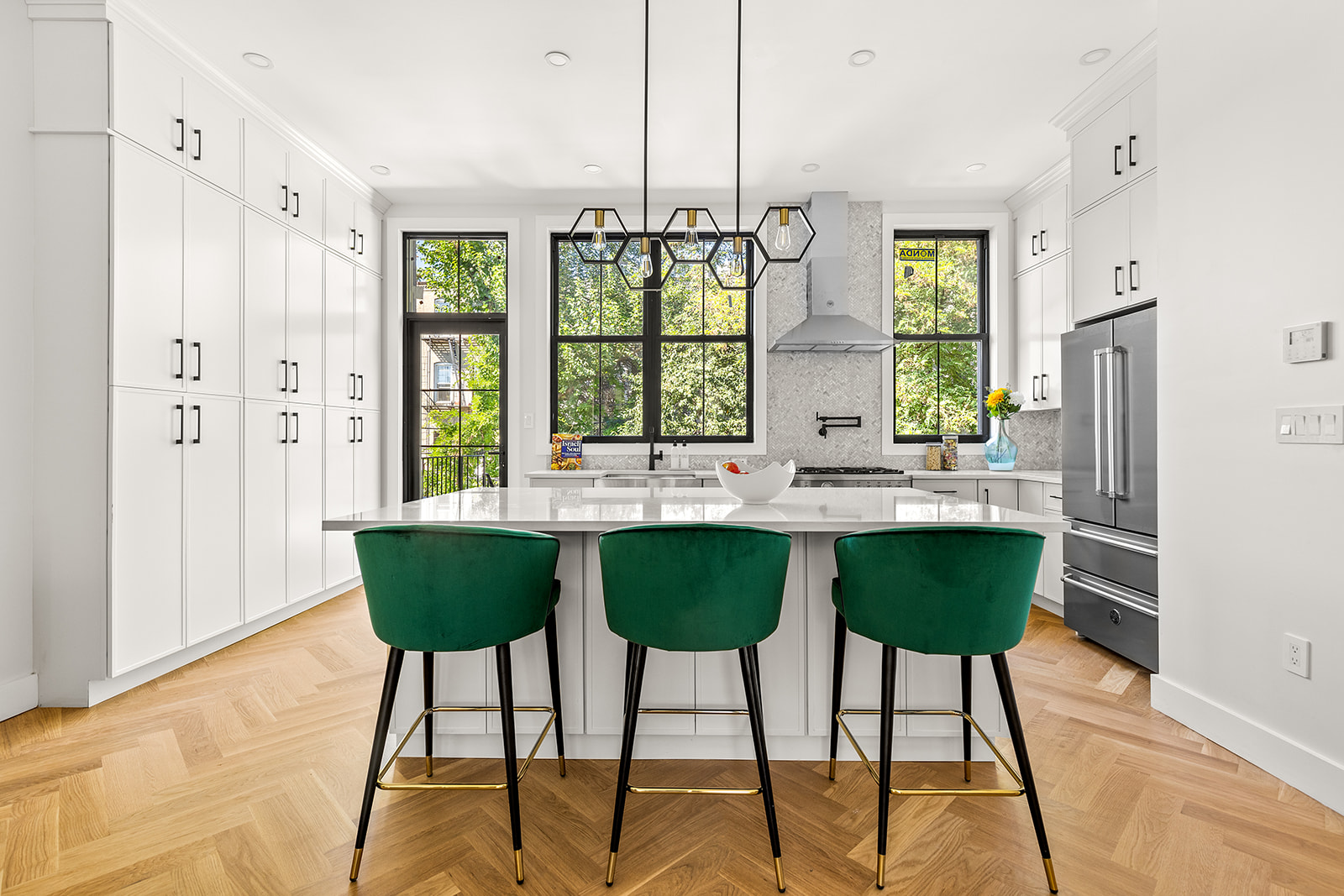 a kitchen with stainless steel appliances granite countertop a table chairs and a large window