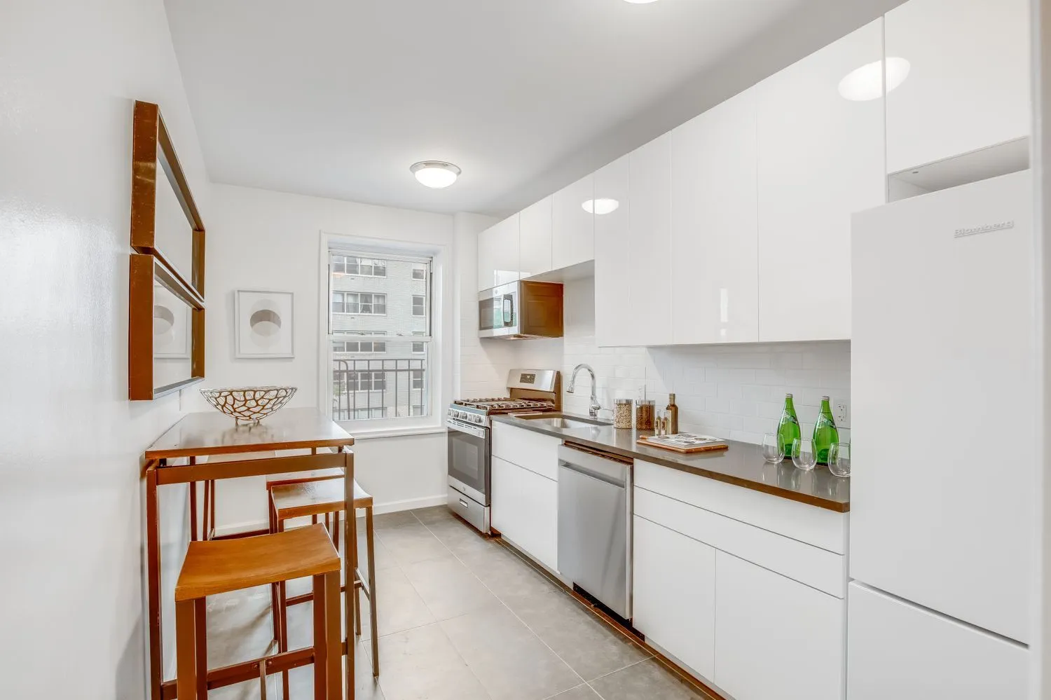 a kitchen with stainless steel appliances a stove a sink cabinets and a refrigerator