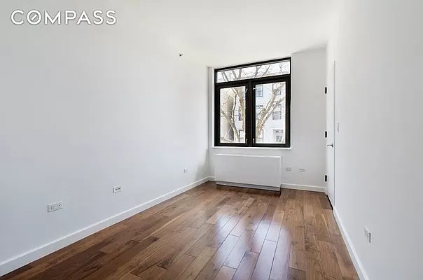 125 North 5th Street, Unit 2E Brooklyn, NY 11249 - Photo 5 of 11 an empty room with wooden floor and windows