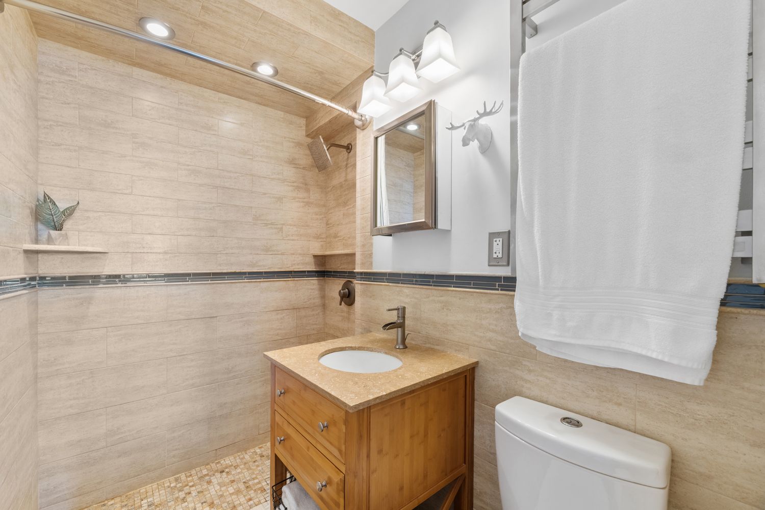 a bathroom with a sink a toilet a mirror and shower