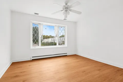 an empty room with a window and a ceiling fan