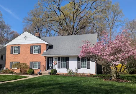 a front view of a house with a yard and trees