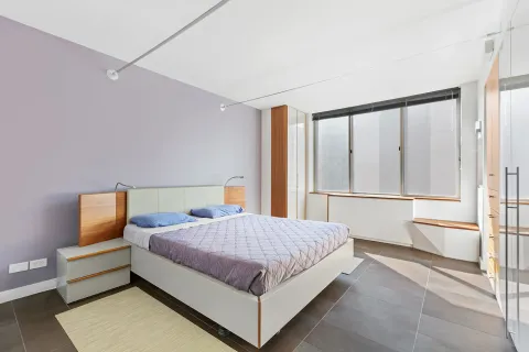 a bedroom with a bed and wooden floor