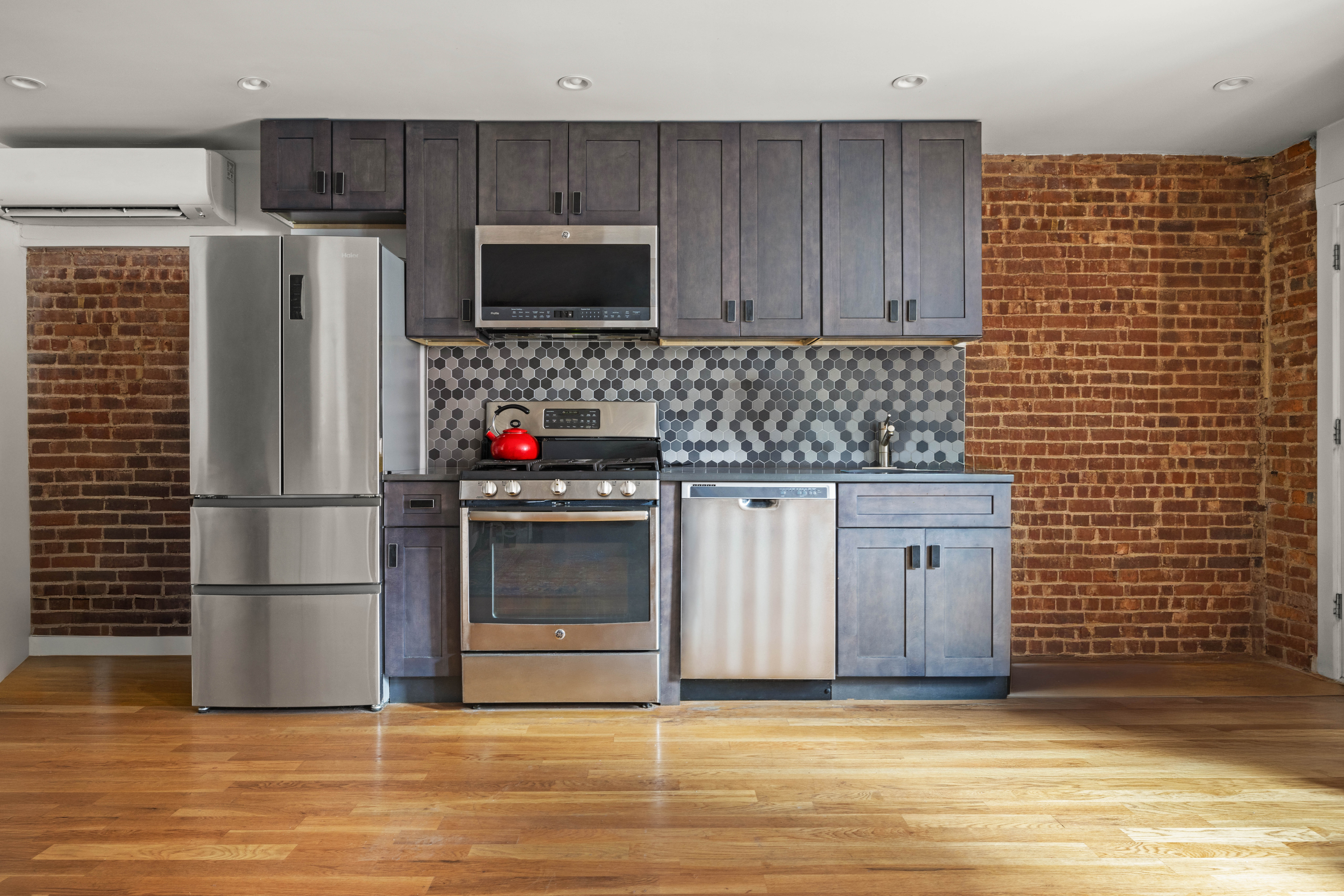 750 Lincoln Place Brooklyn, NY 11216 - Photo 21 of 24 a kitchen with stainless steel appliances granite countertop a stove a refrigerator and a microwave