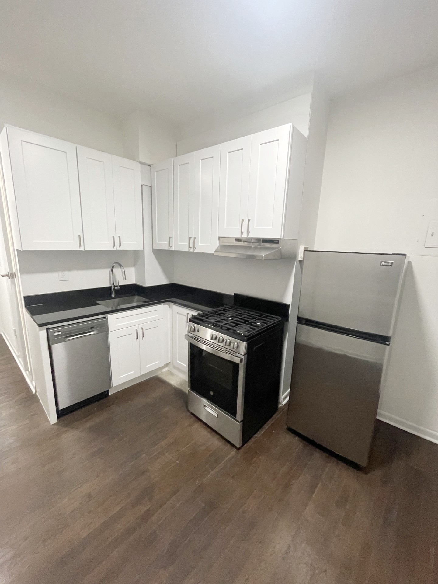 a kitchen with stainless steel appliances granite countertop a stove a sink and a refrigerator