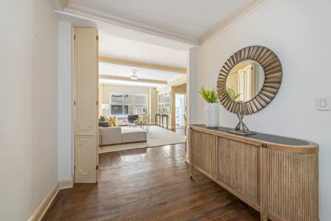 a hallway with a large mirror and a wooden floor