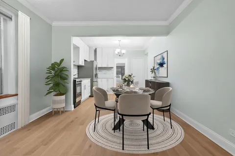 a dining room with furniture potted plants and wooden floor