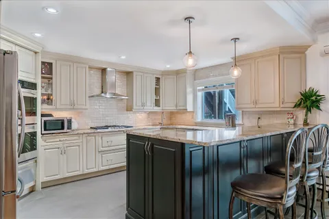 a kitchen with stainless steel appliances granite countertop sink stove top oven and cabinets