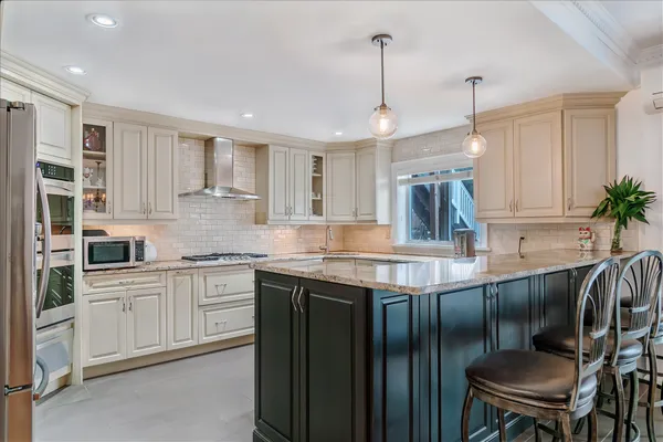 a kitchen with stainless steel appliances granite countertop sink stove top oven and cabinets
