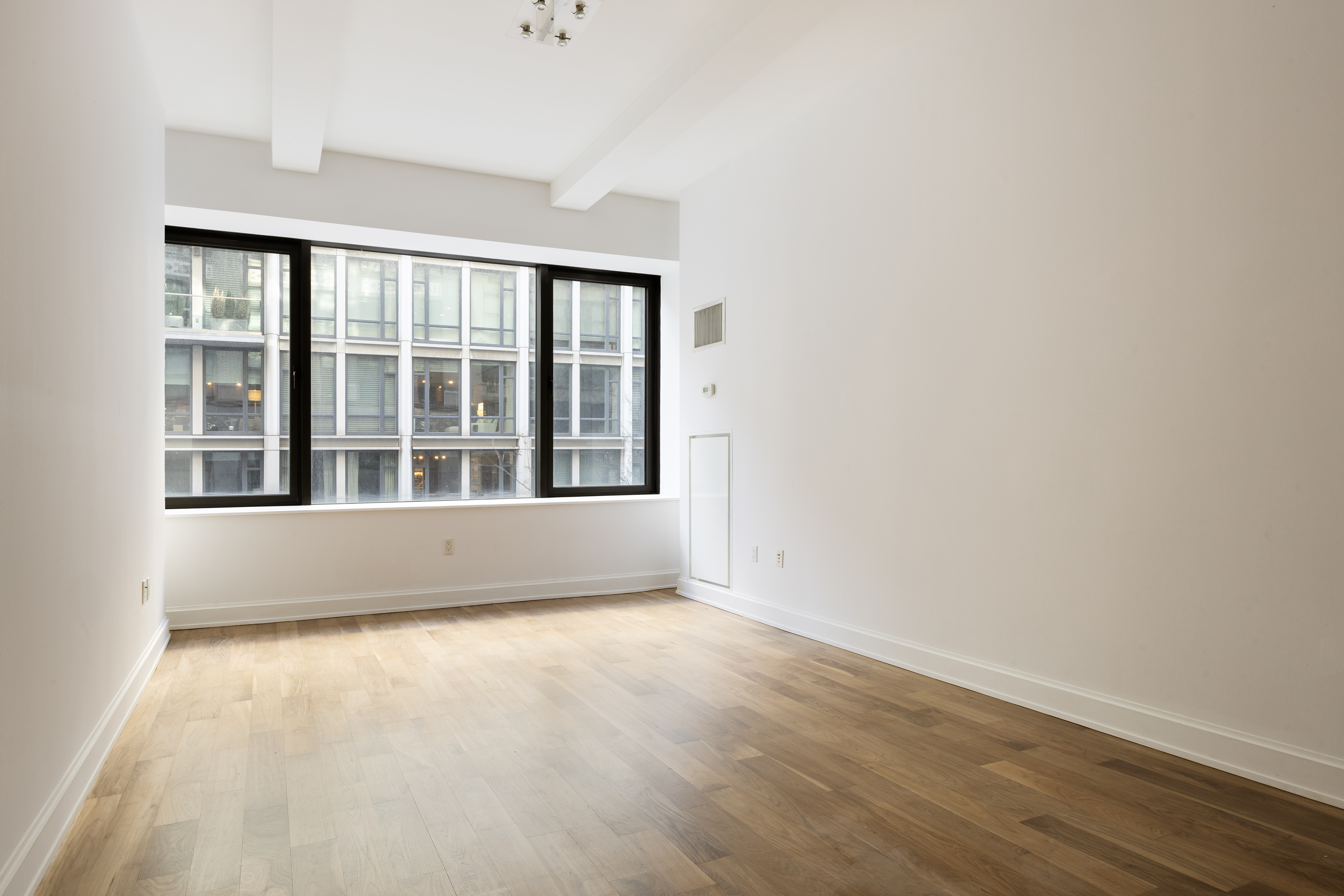 140 West 22nd Street, Unit 2B Manhattan, NY 10011 - Photo 1 of 12 an empty room with wooden floor and windows