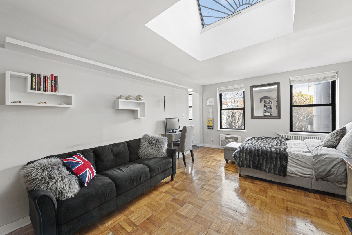 87 St Marks Place, Unit 4E Manhattan, NY 10009 - Photo 2 of 9 a living room with furniture and a window