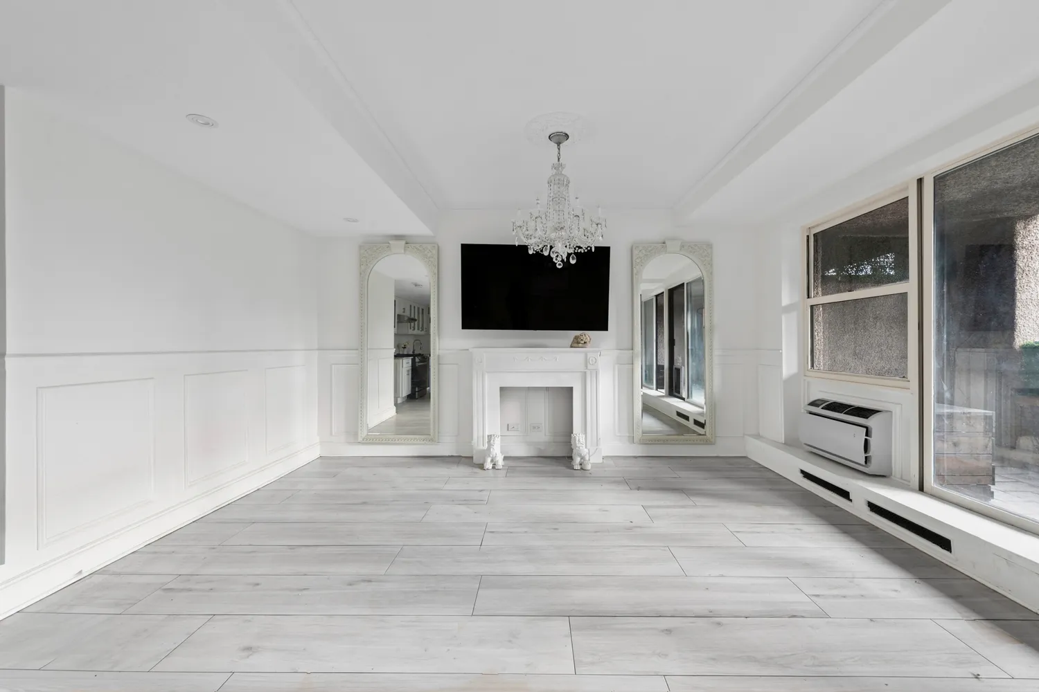 a view of a livingroom with a flat screen tv wooden floor and a window