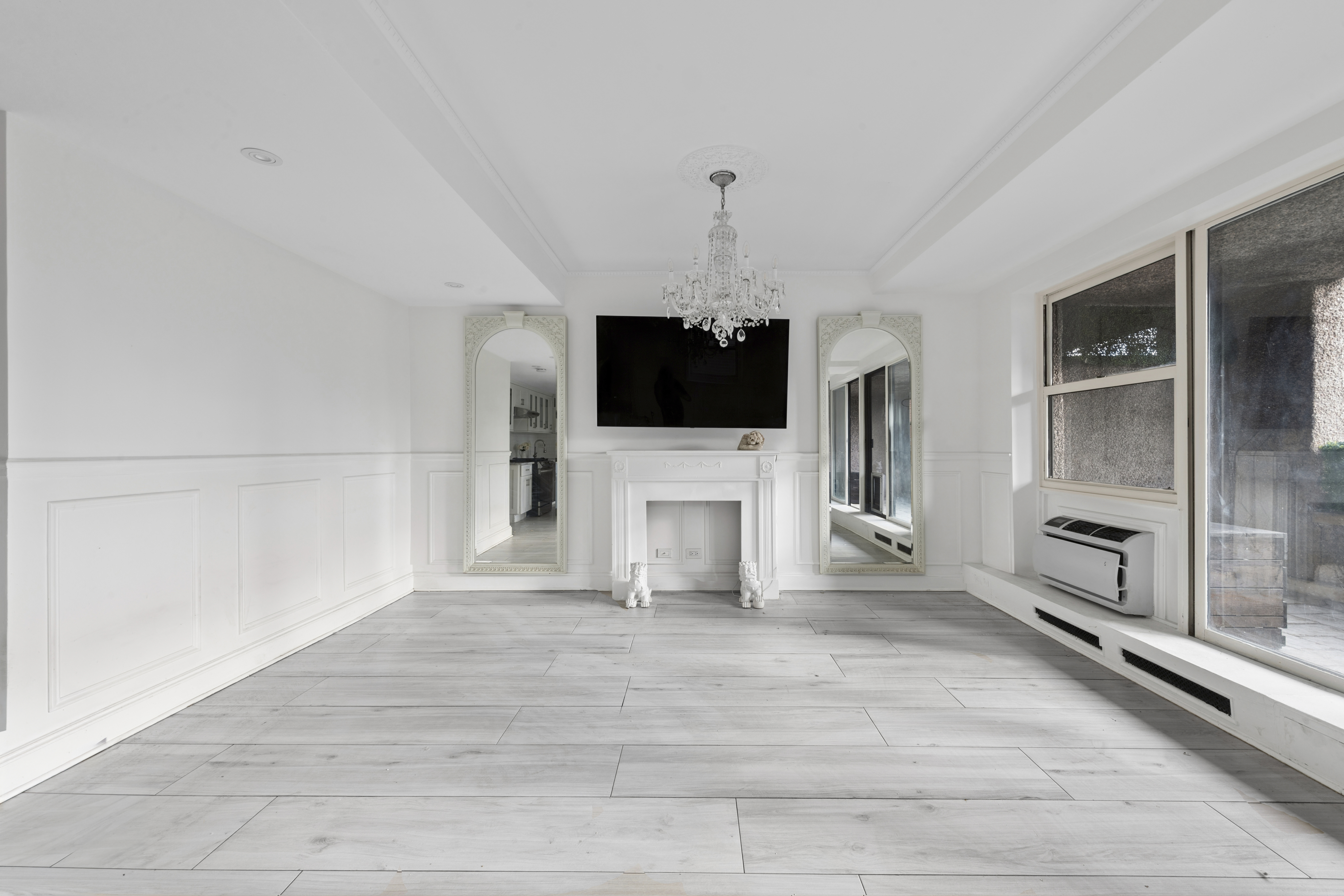 350 East 62nd Street, Unit PHD Manhattan, NY 10065 - Photo 5 of 15 a view of a livingroom with a flat screen tv wooden floor and a window