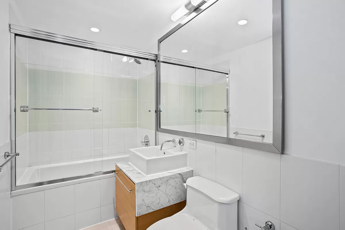100 West 39th Street, Unit 37E Manhattan, NY 10018 - Photo 6 of 11 a bathroom with a bathtub shower sink vanity and toilet