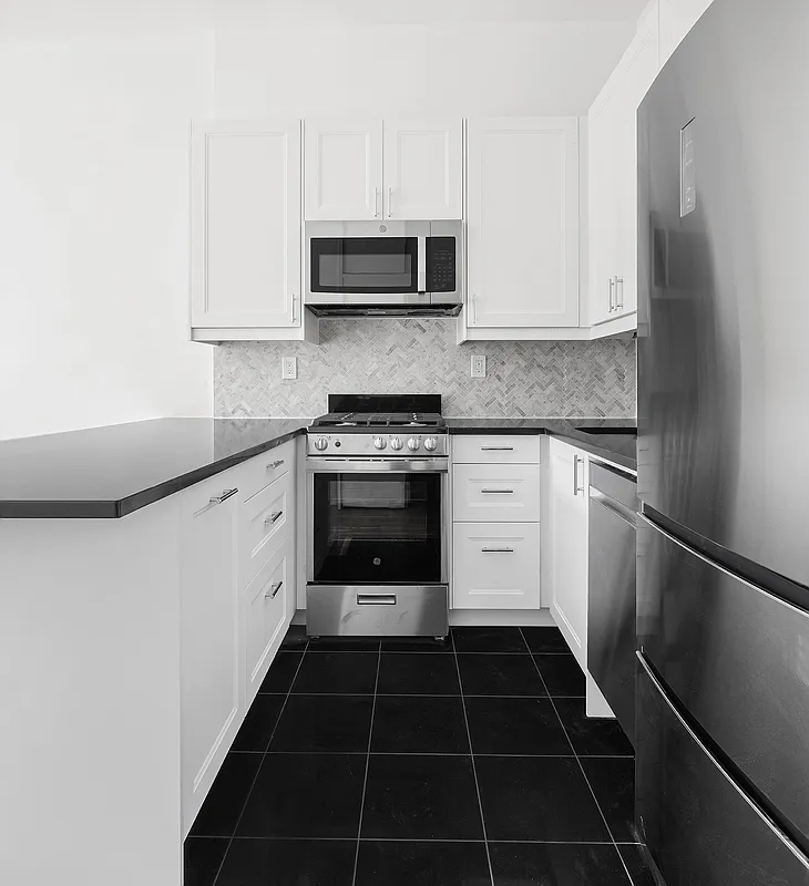 421 West 57th Street, Unit 3C Manhattan, NY 10019 - Photo 7 of 18 a kitchen with a sink stove and cabinets