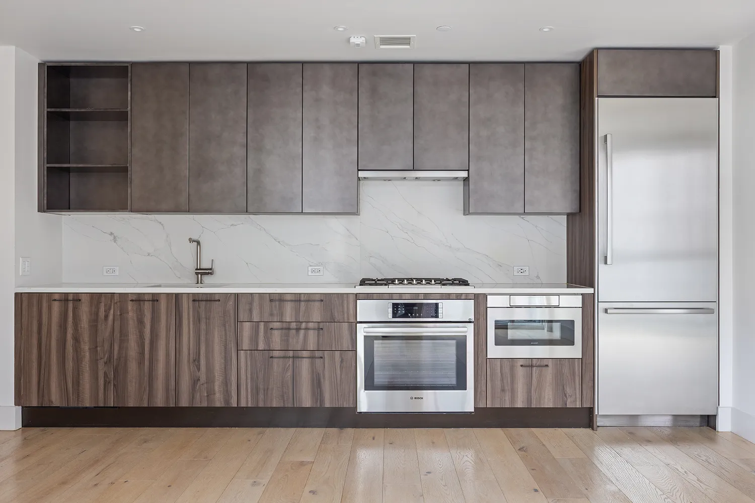 a view of a kitchen with a sink stove cabinets and empty room