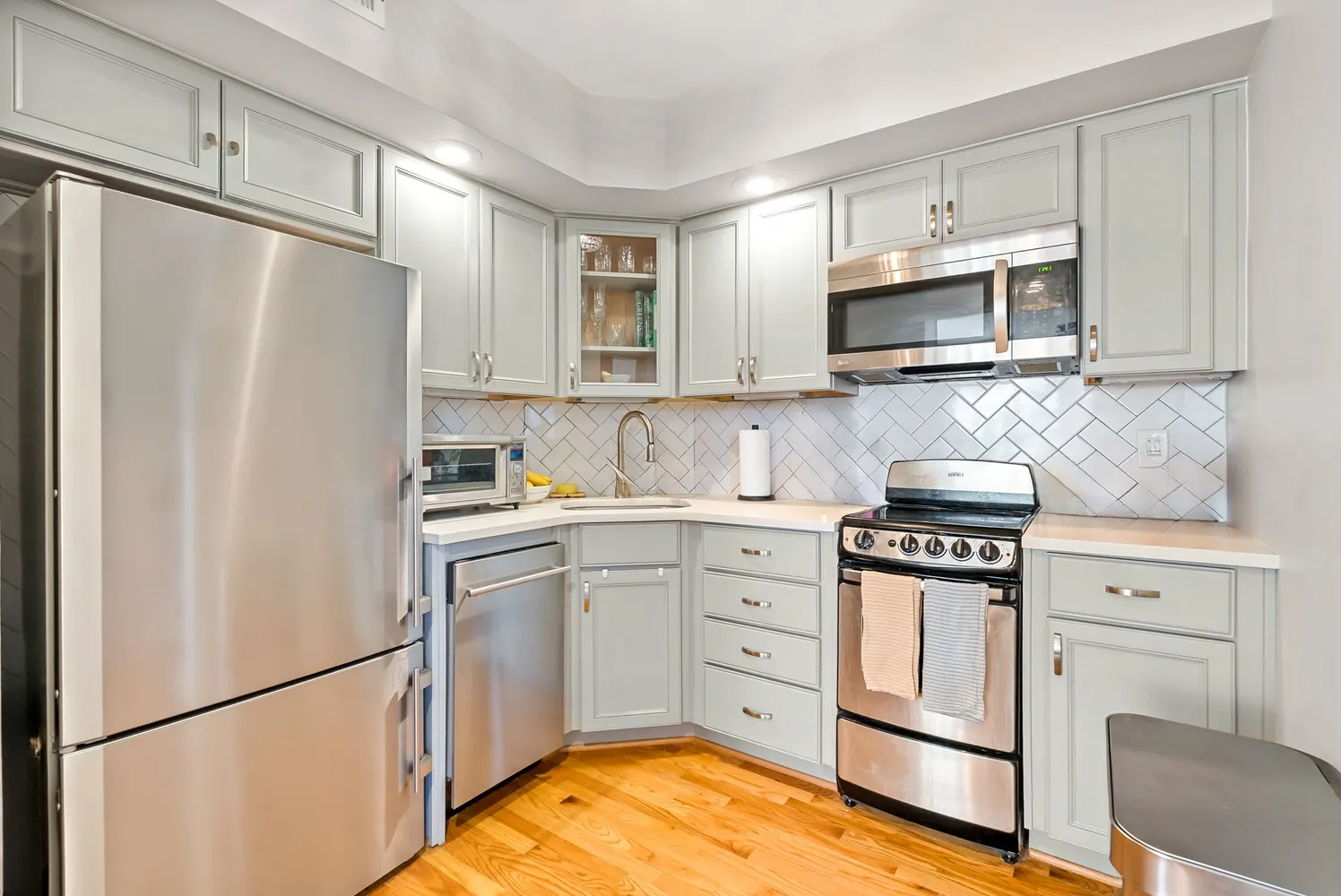 a kitchen with stainless steel appliances granite countertop a refrigerator stove a sink dishwasher and microwave with cabinets