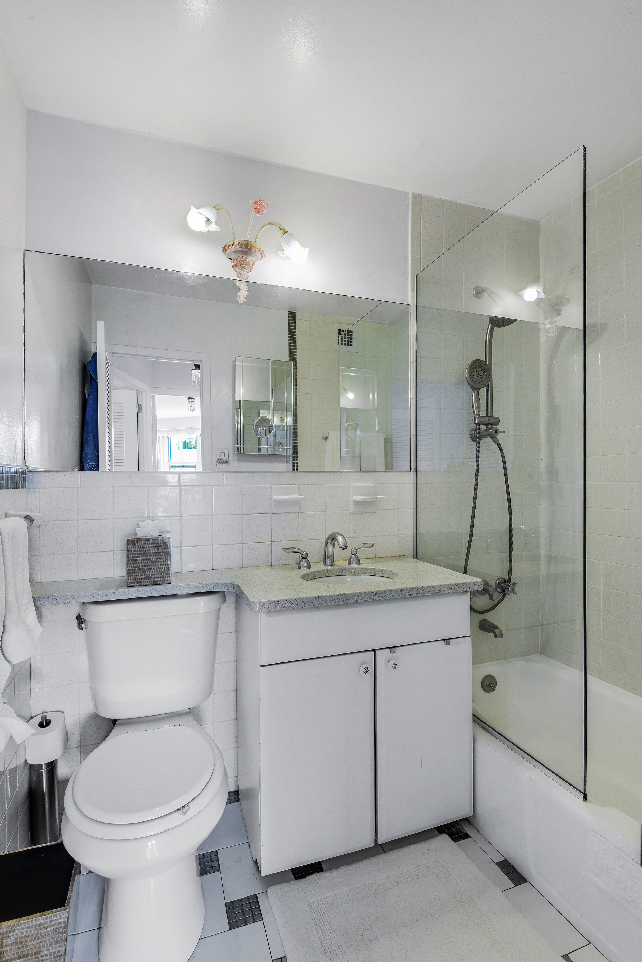 305 East 24th Street, Unit 18C Manhattan, NY 10010 - Photo 12 of 13 a bathroom with a toilet sink and mirror