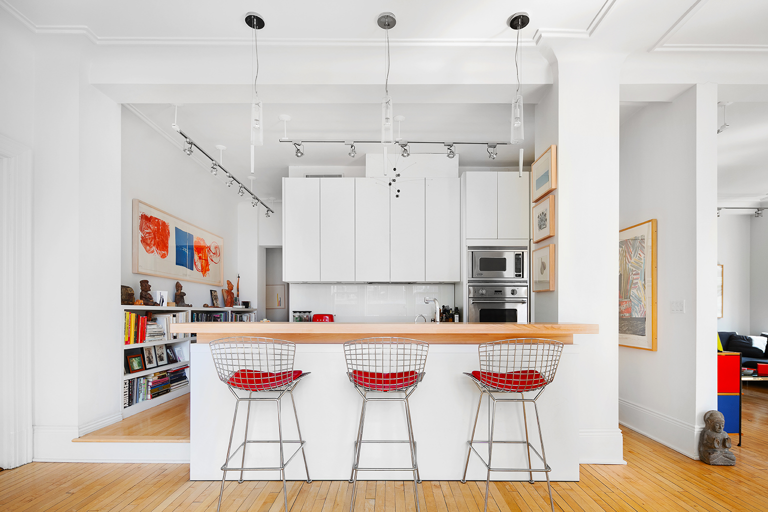366 Broadway, Unit 8A Manhattan, NY 10013 - Photo 5 of 13 a kitchen with stainless steel appliances kitchen island granite countertop a table chairs and a refrigerator