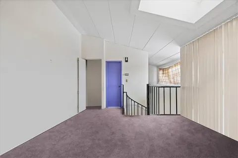 a view of a hallway with a window and stairs