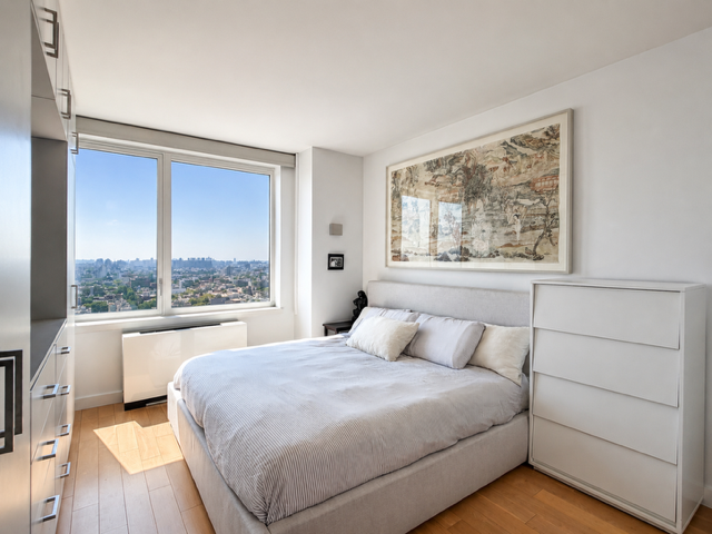 22 North 6th Street, Unit 23K Brooklyn, NY 11249 - Photo 6 of 11 a bedroom with a large bed and a large window