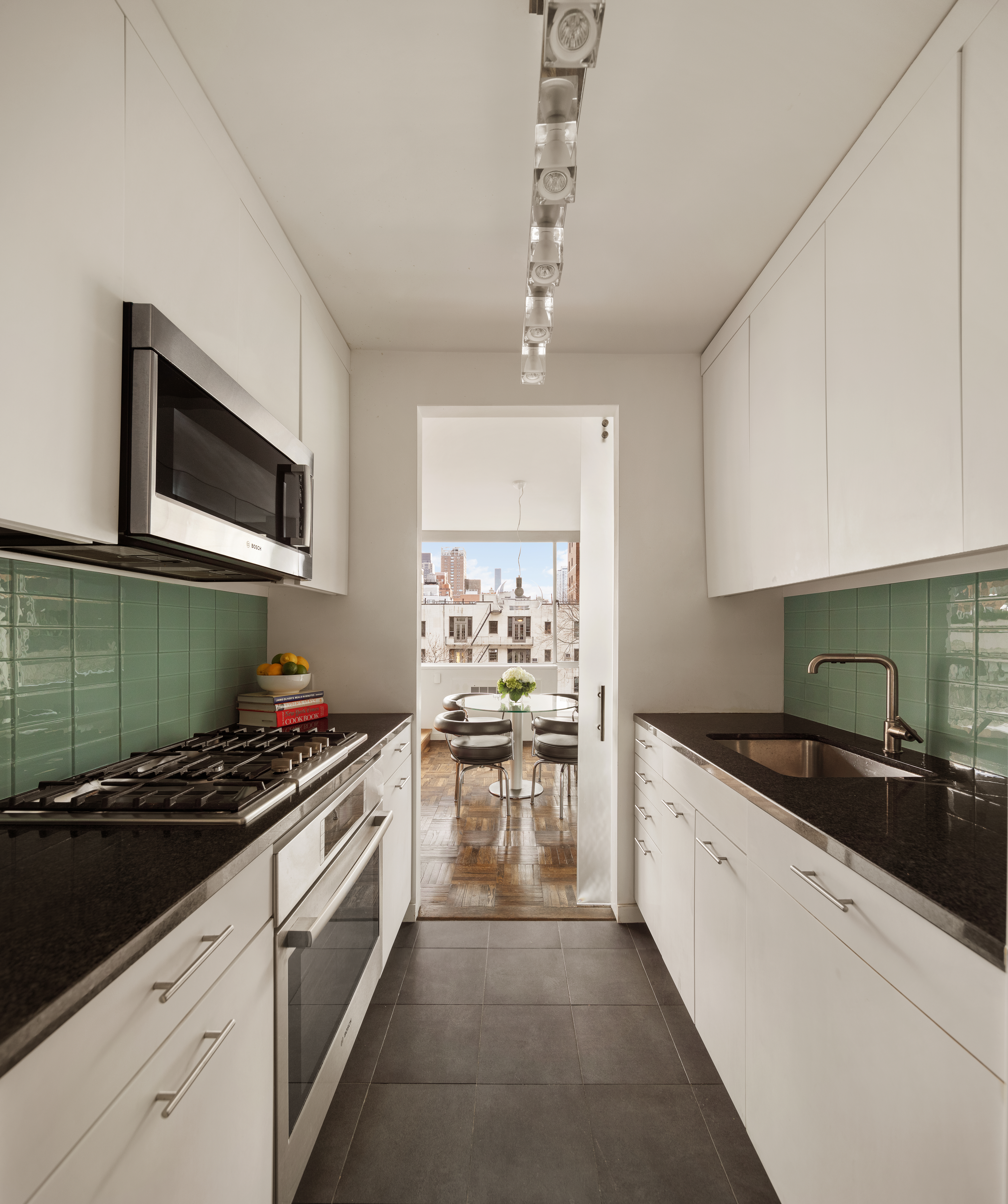 333 East 69th Street, Unit 7F Manhattan, NY 10021 - Photo 4 of 12 a kitchen with stainless steel appliances kitchen island granite countertop a stove and a sink