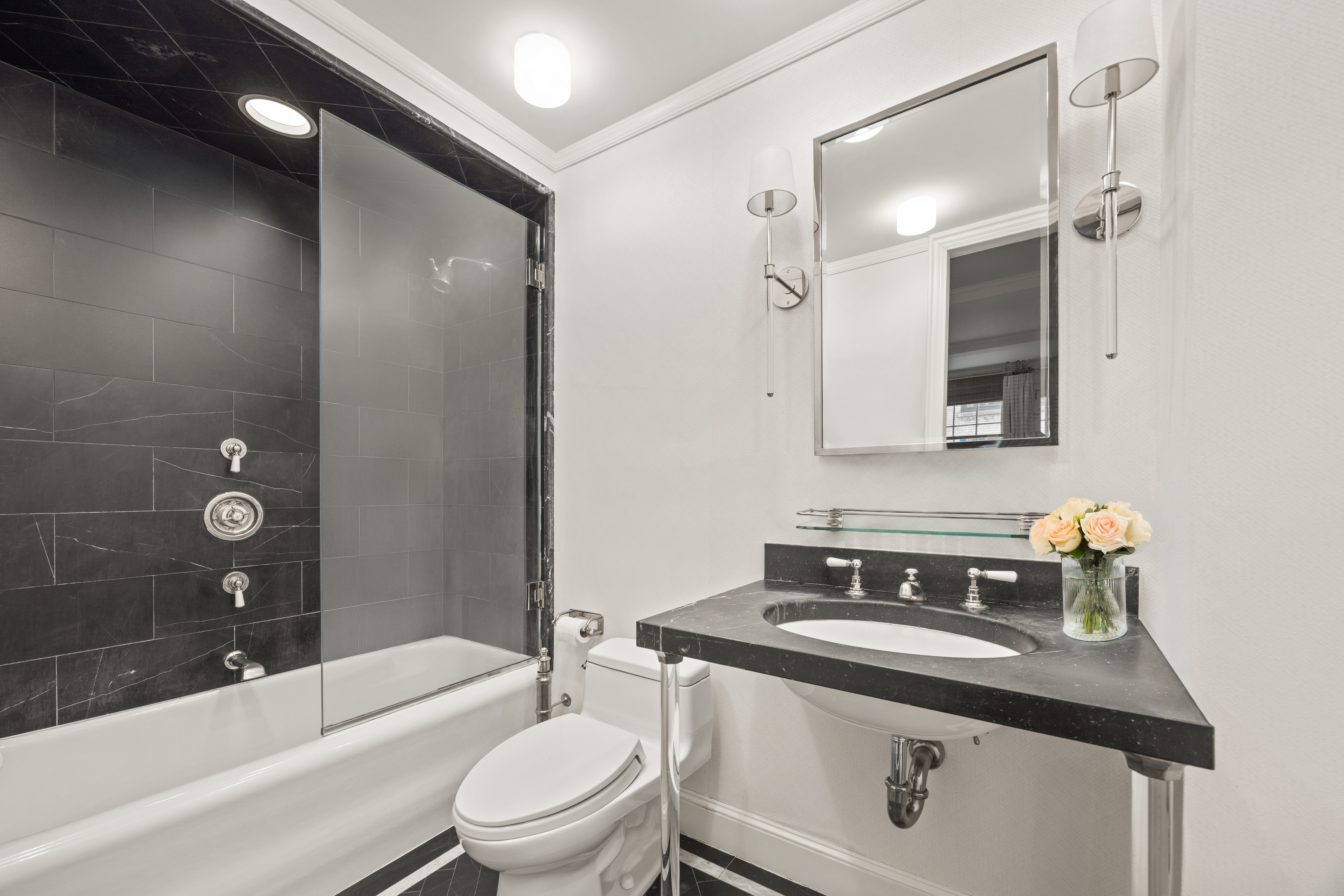 23 East 74th Street, Unit 7E Manhattan, NY 10021 - Photo 7 of 8 a bathroom with a sink a toilet a mirror and bathtub