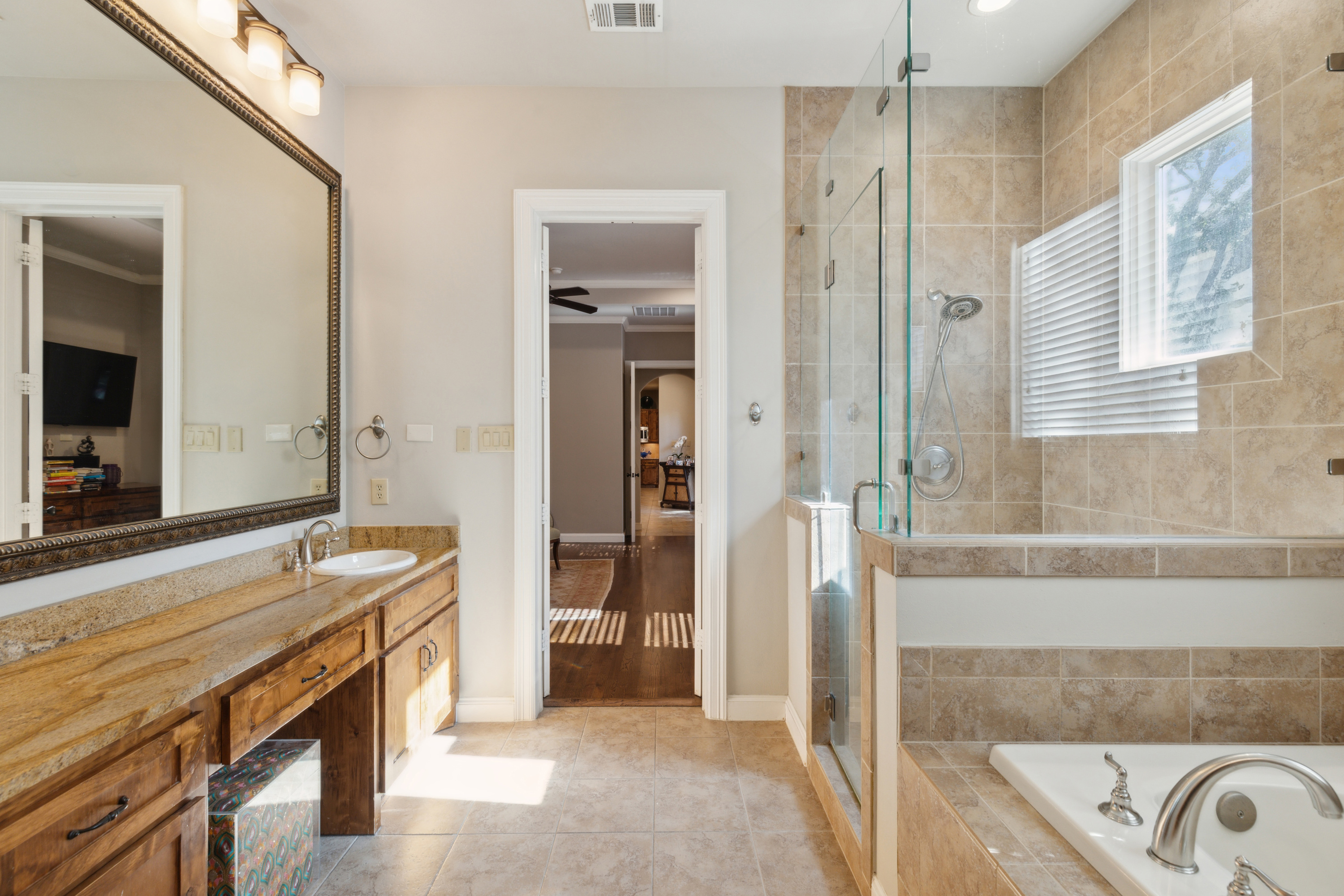 8411 Midway Road Dallas, TX 75209 - Photo 23 of 29 a spacious bathroom with a granite countertop sink and a mirror