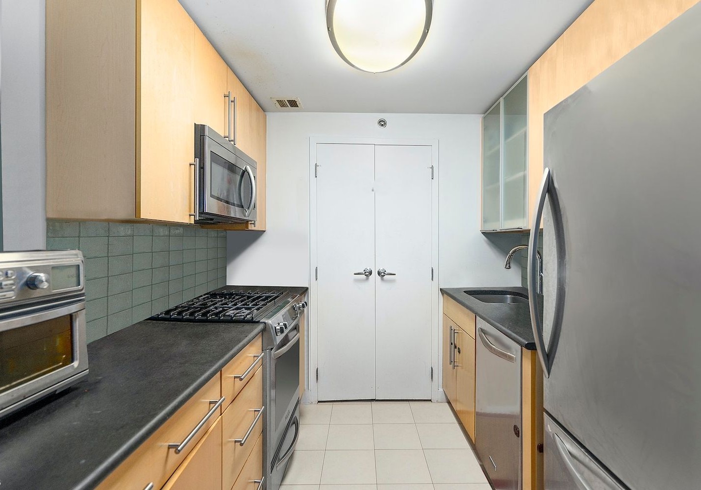 40 West 116th Street, Unit B503 Manhattan, NY 10026 - Photo 6 of 36 a kitchen with granite countertop a stove and a refrigerator