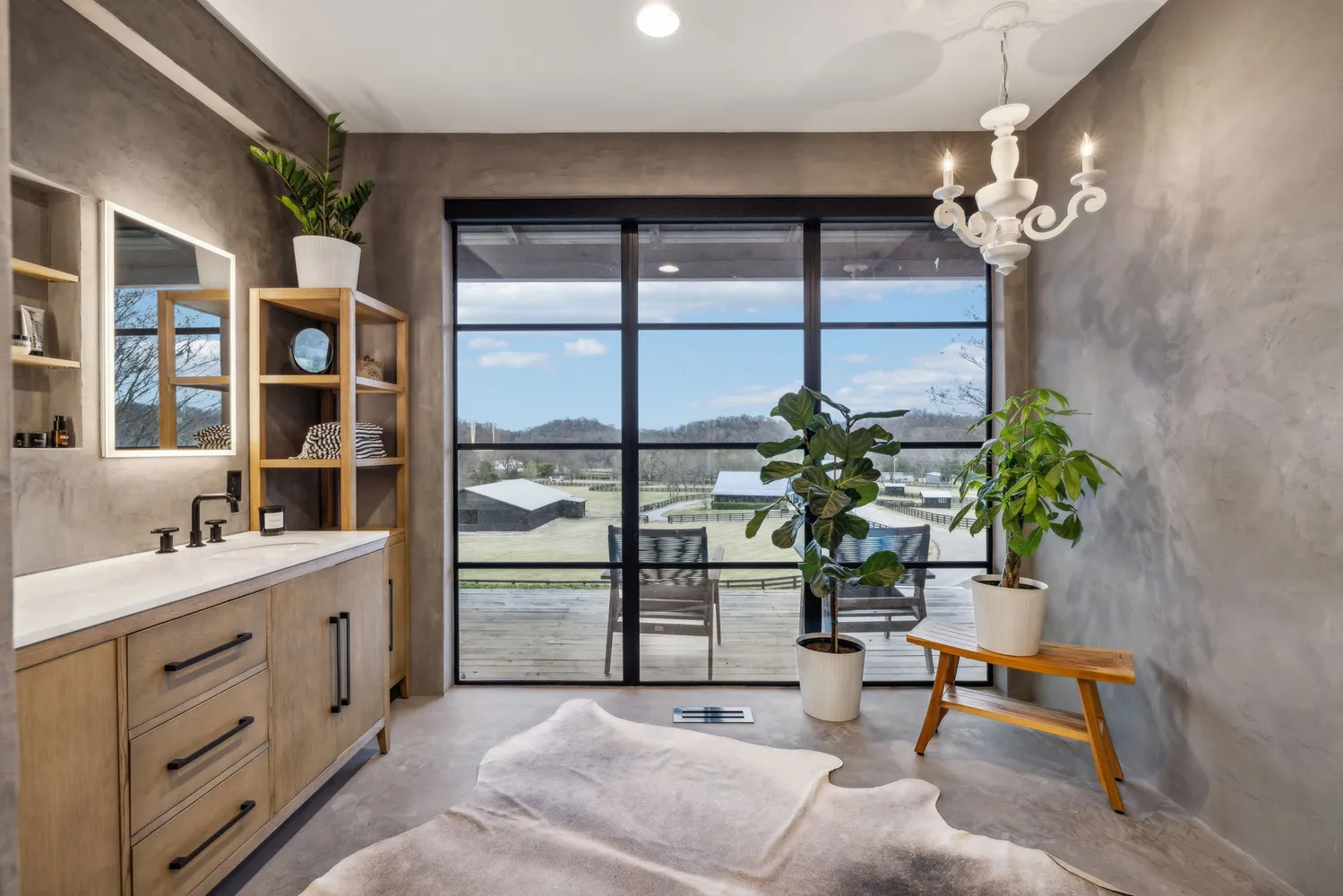 a living room with furniture a chandelier and a potted plant