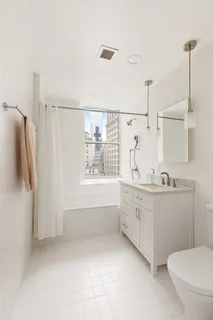 a bathroom with a granite countertop sink a toilet and shower