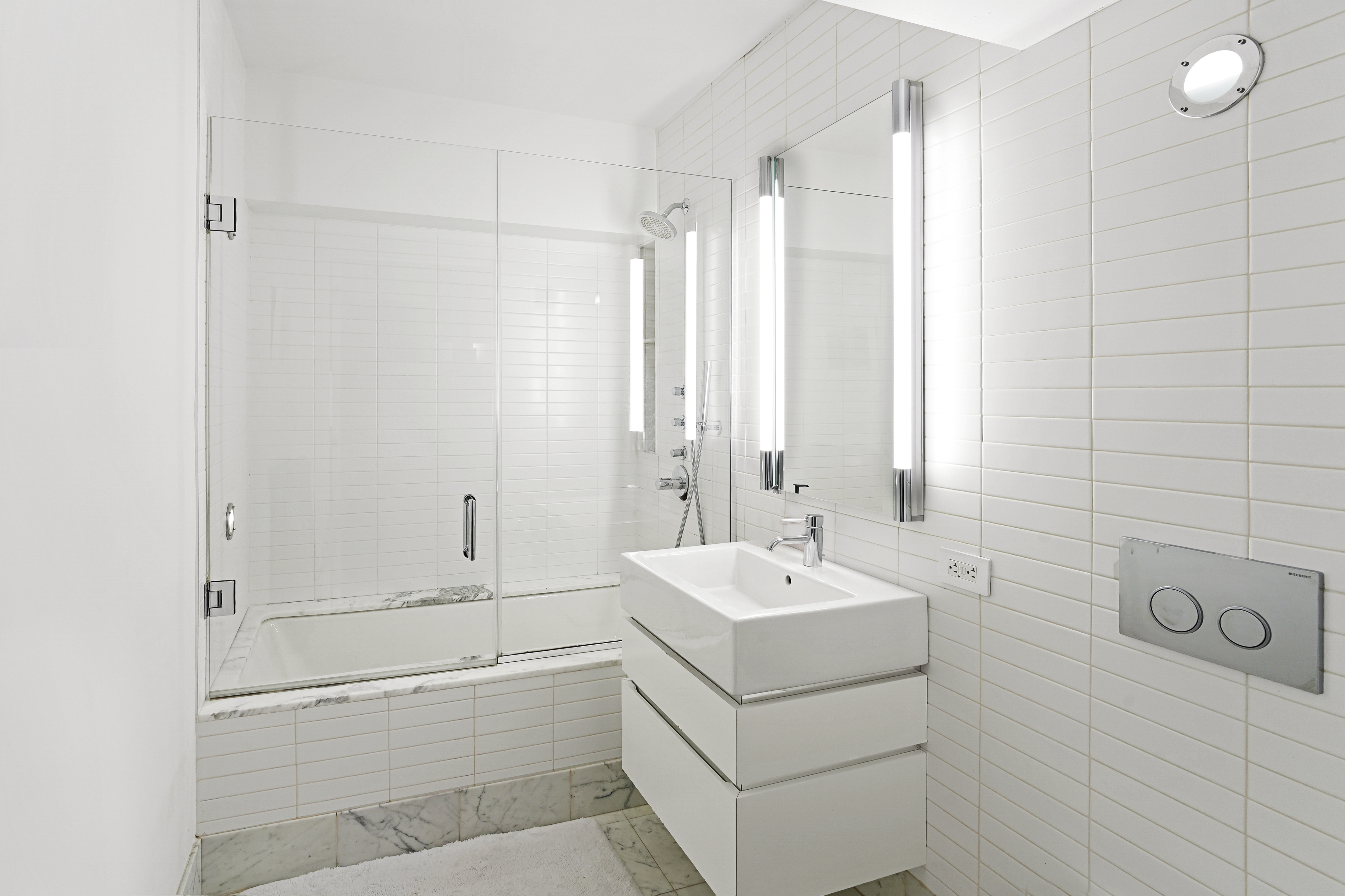 421 Hudson Street, Unit 221 Manhattan, NY 10014 - Photo 11 of 12 a bathroom with a double vanity sink a mirror and a bathtub