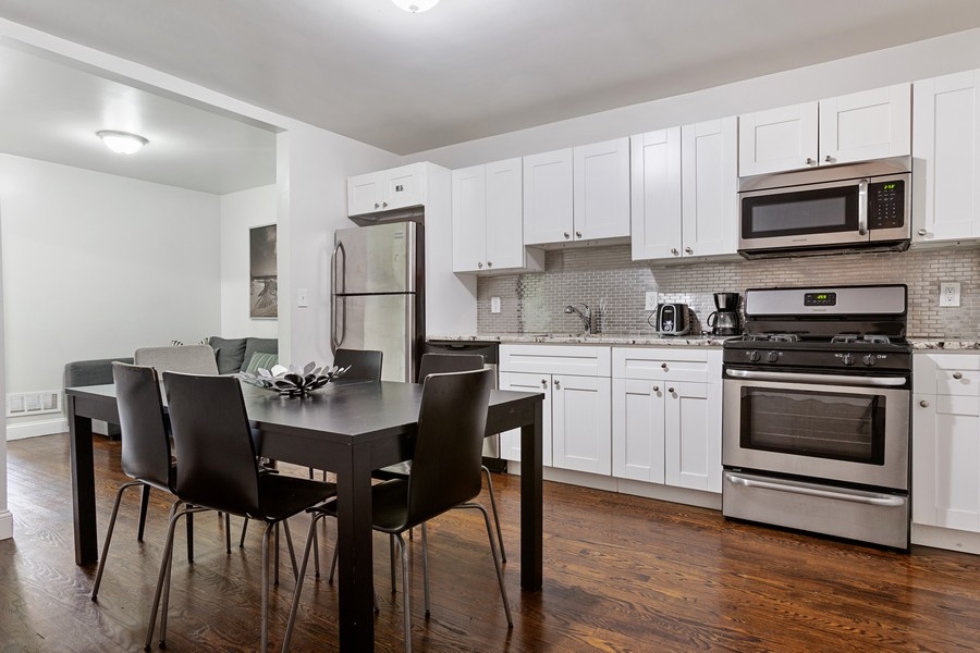 673 Metropolitan Avenue, Unit 2 Brooklyn, NY 11211 - Photo 3 of 12 a kitchen with a table chairs microwave and cabinets
