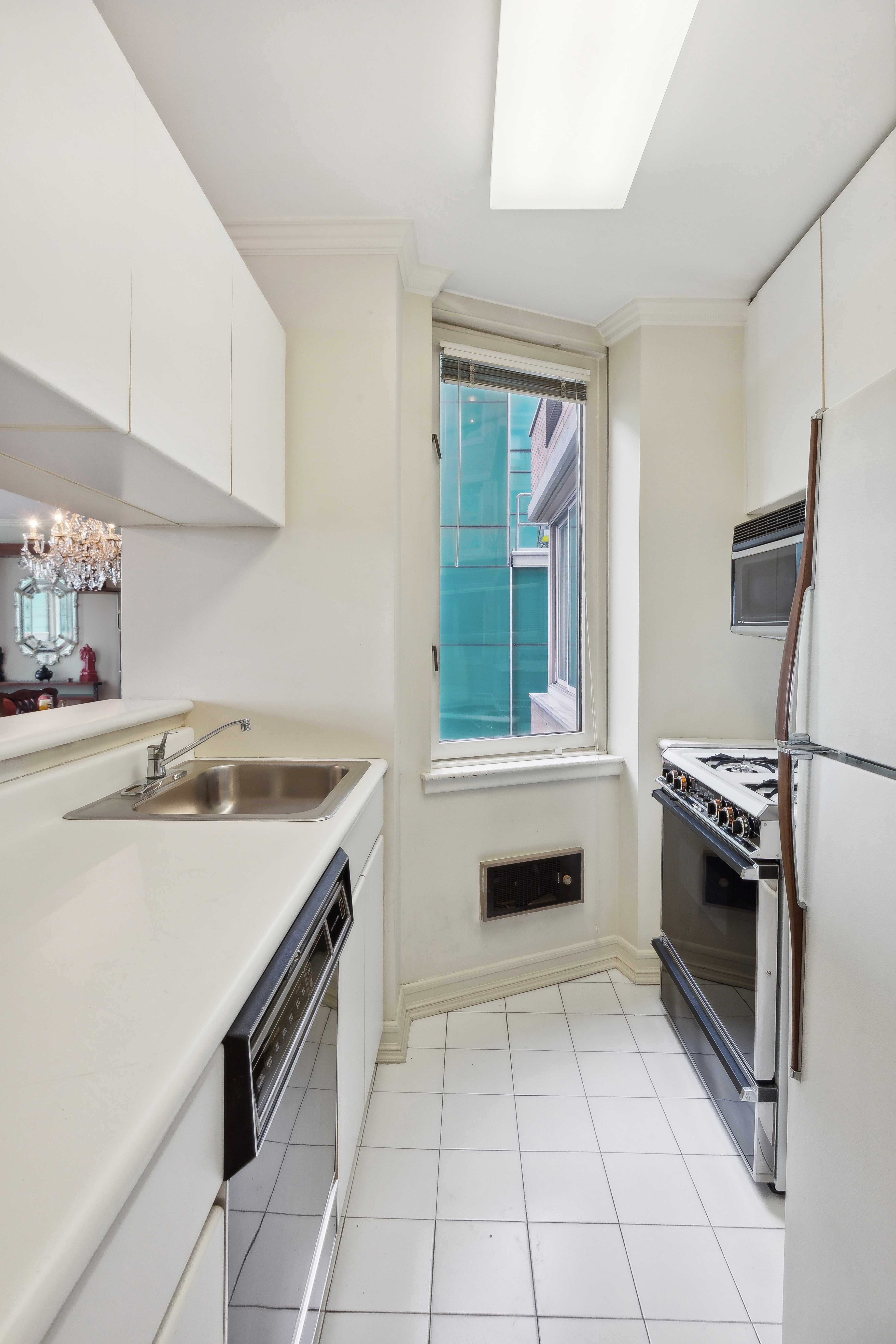 235 East 40th Street, Unit 37C Manhattan, NY 10016 - Photo 3 of 10 a kitchen with granite countertop a sink stove and cabinets